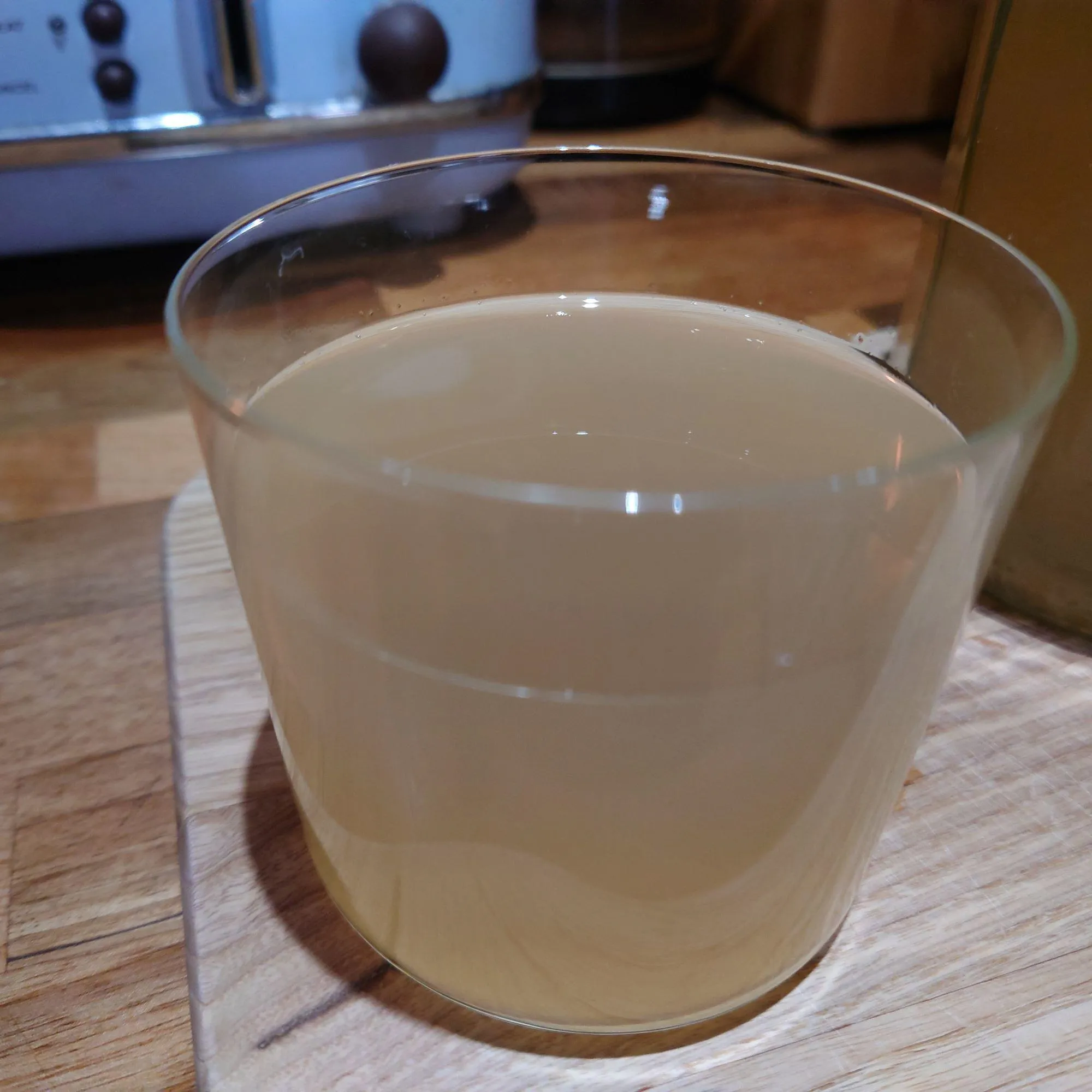 Glass of home made lemon barley water on a kitchen surface