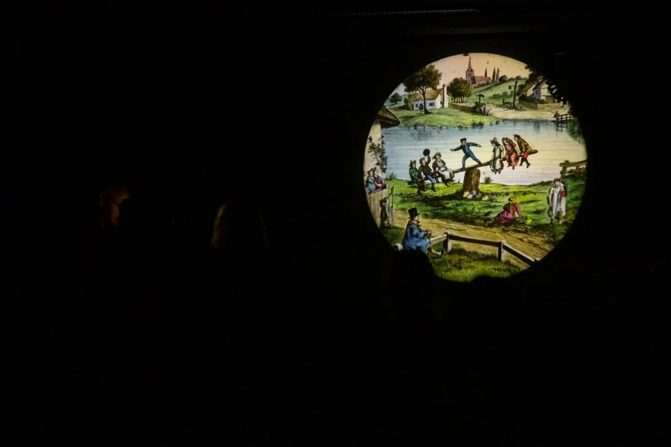 a slide of children playing on a see-saw in a bucolic scene
