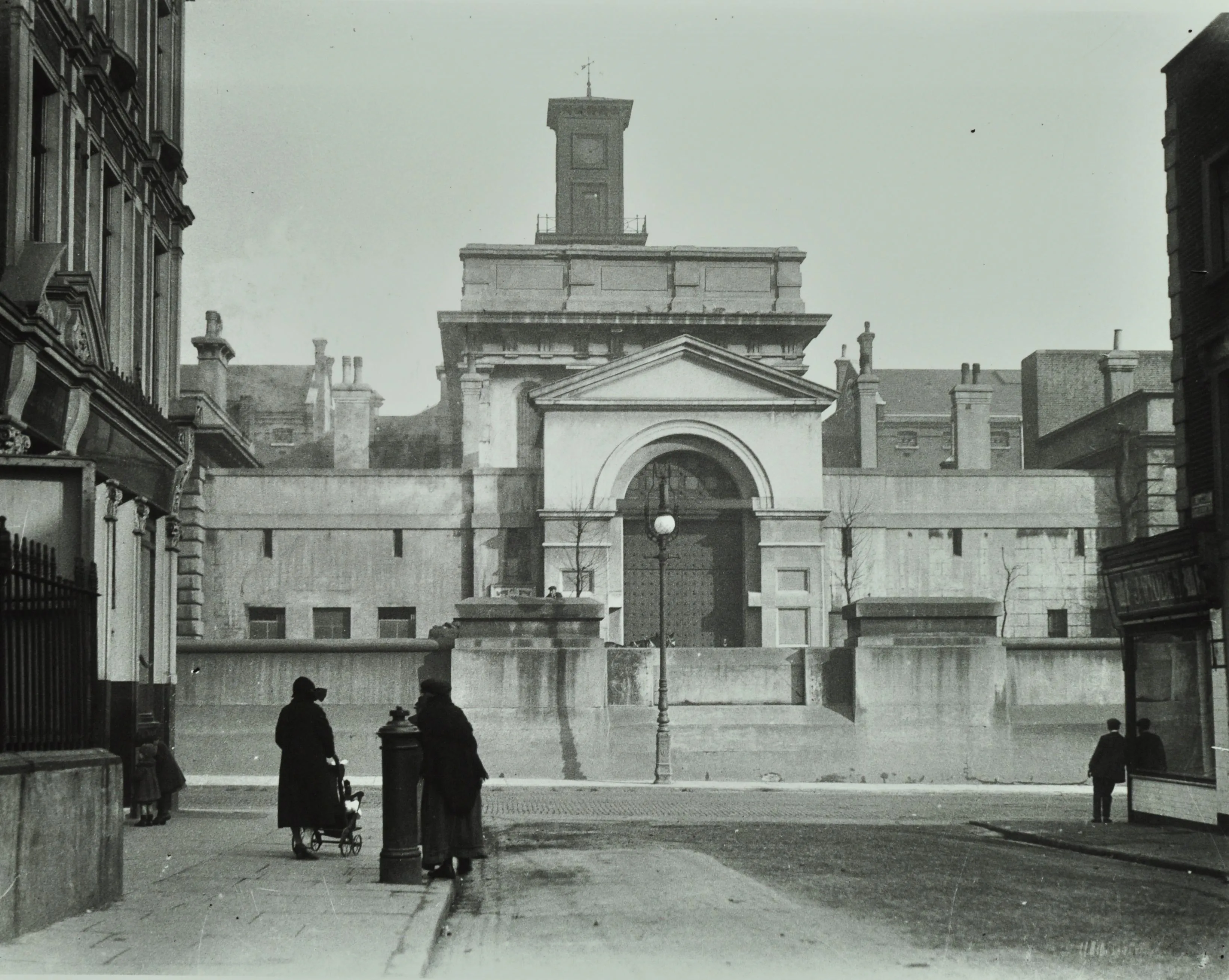 classical architectural entrance to a prison with people in the foreground