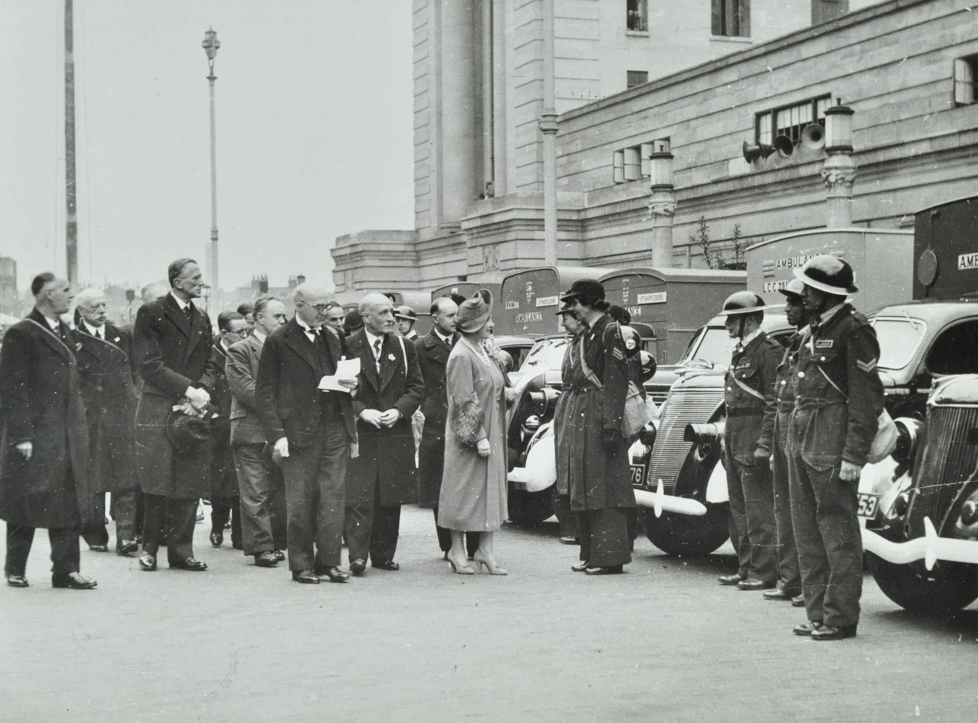 a crowd of officials meeting uniformed officers outside County Hall