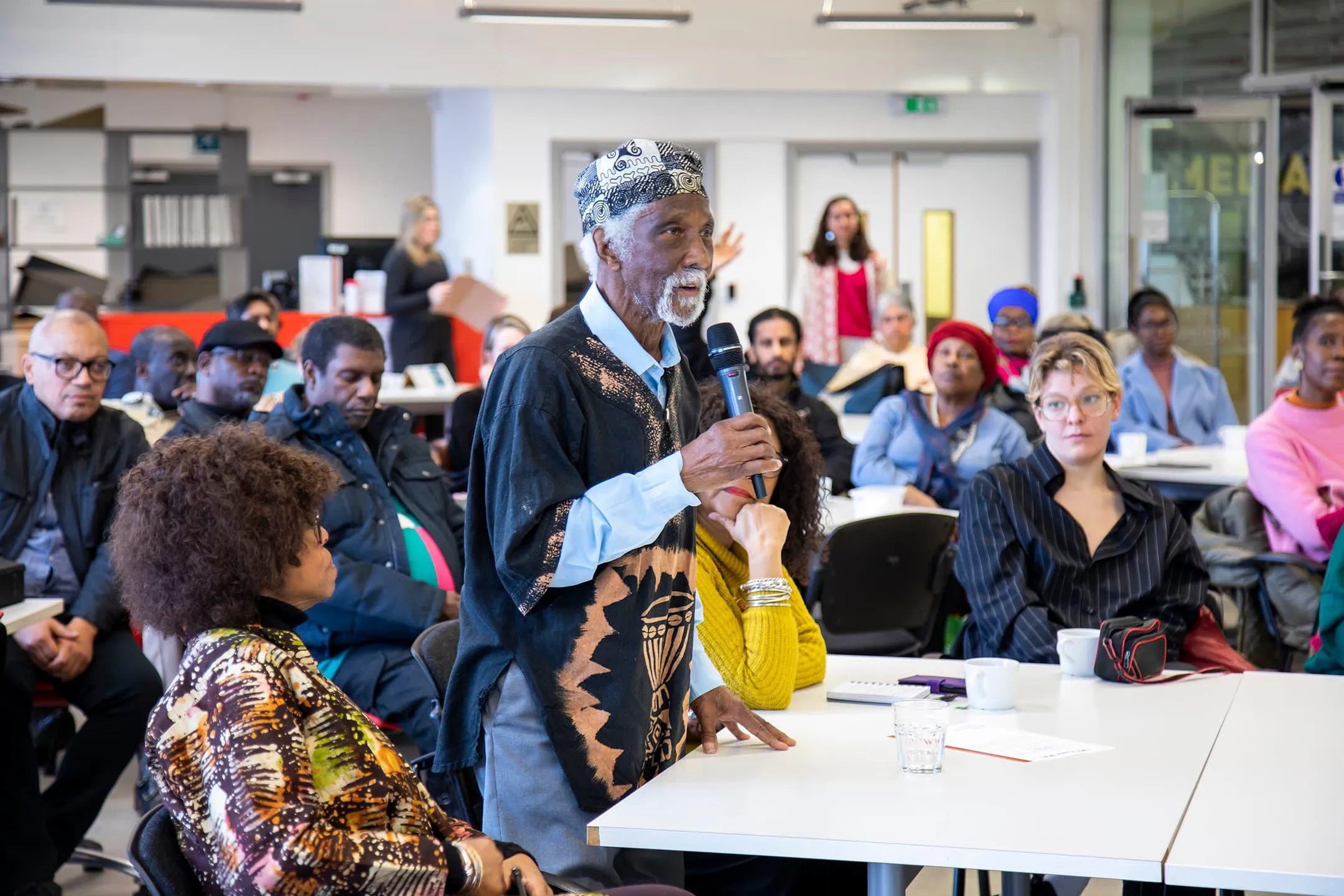 Man with a microphone speaking to an audience