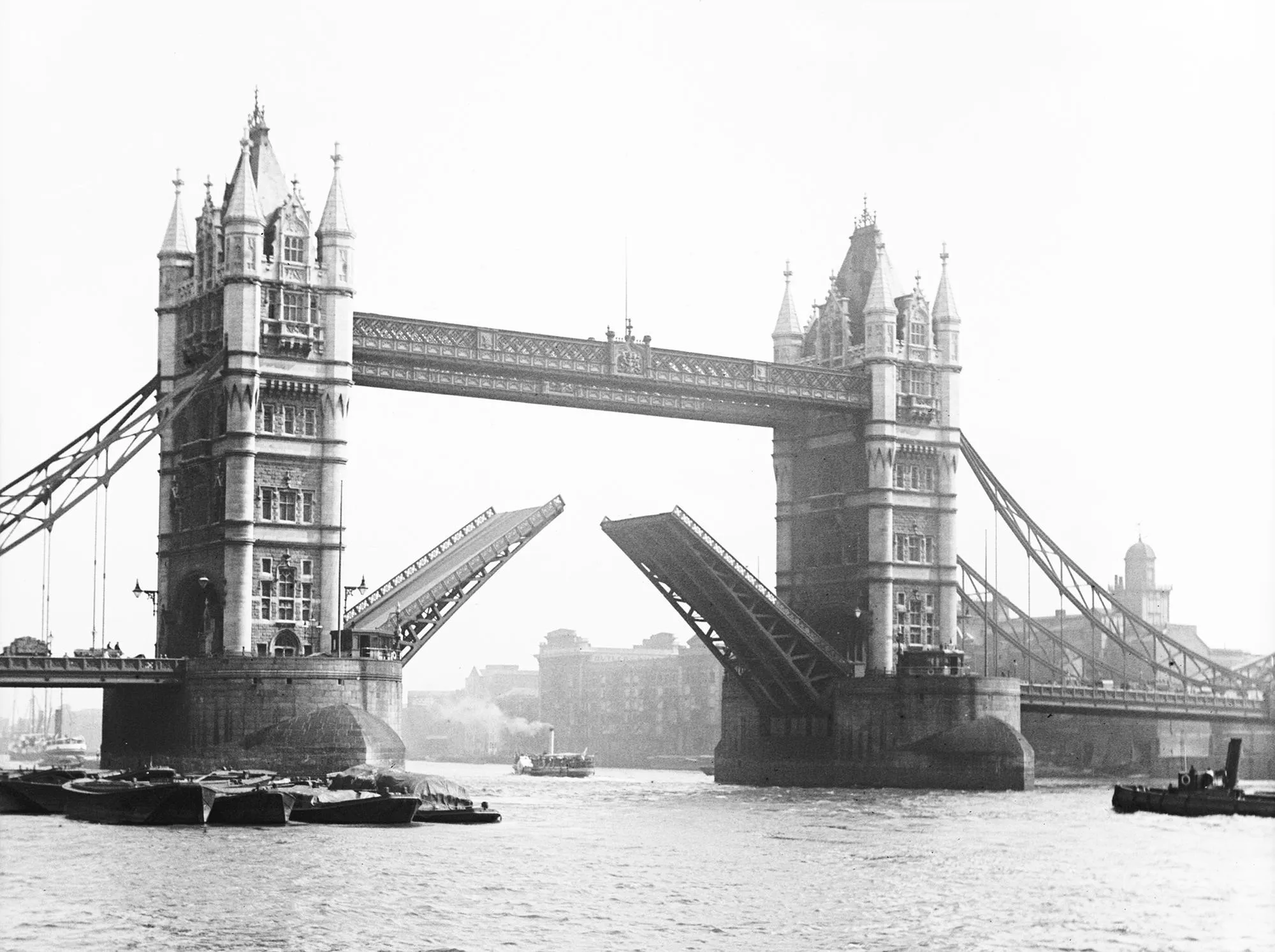 Tower Bridge with barges in the foreground - the bridge is open to let boats through